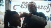 African American barber trimming a client's hair.