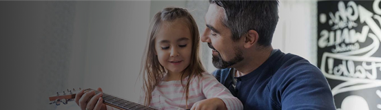 Father and young daughter playing guitar