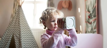 A little girl looking inside a cookie jar