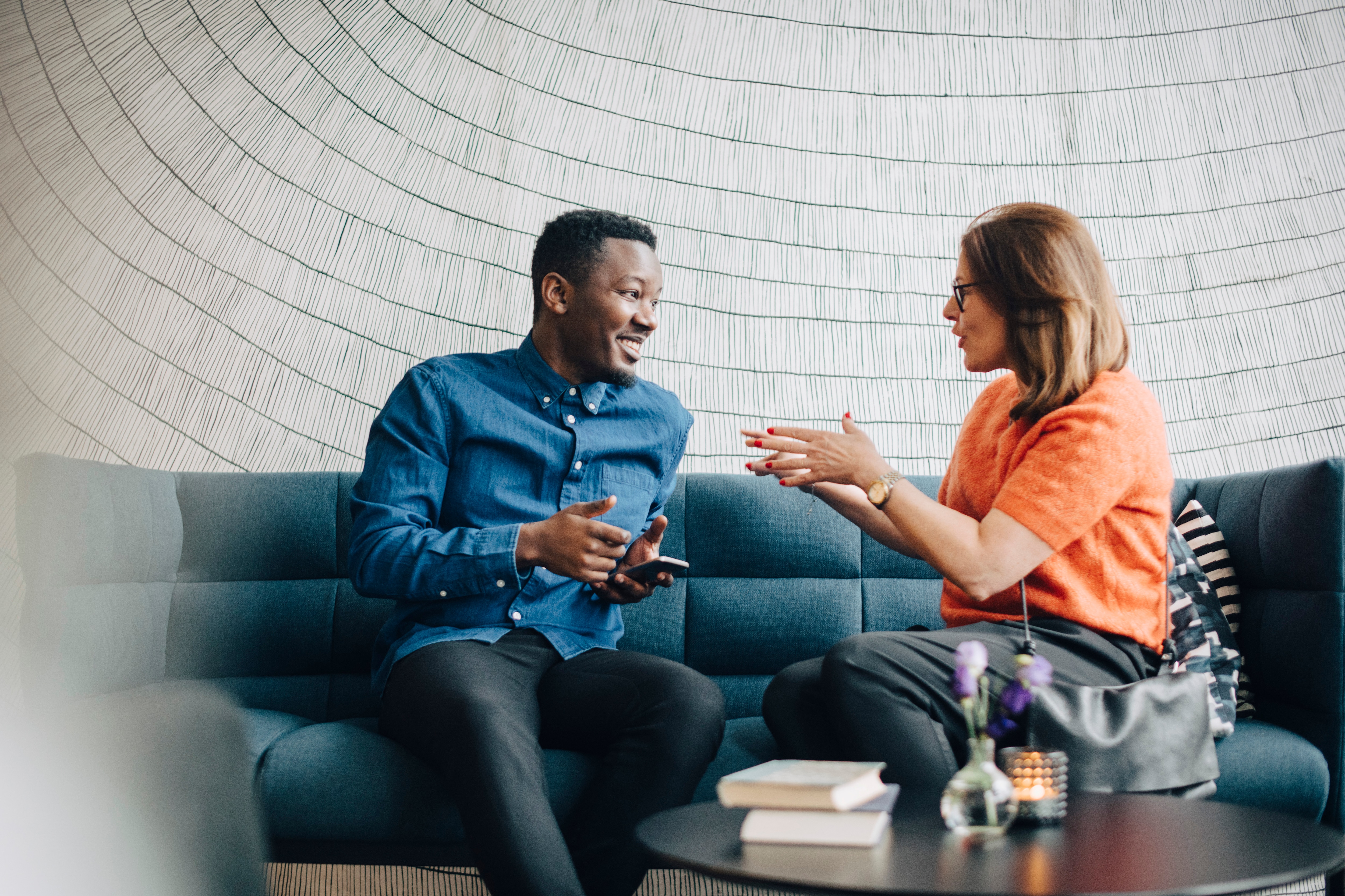 Man and woman sitting on a couch having a discussion