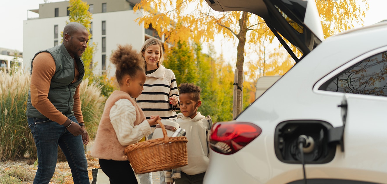 Family loading picnic basked in to trunk