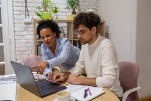 one male and female collaborating at a round table